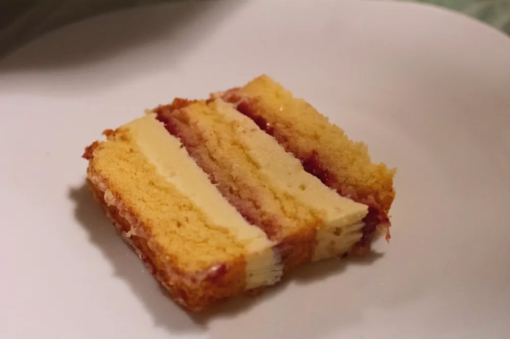 Fatia de bolo branco com recheio de ninho e geleia